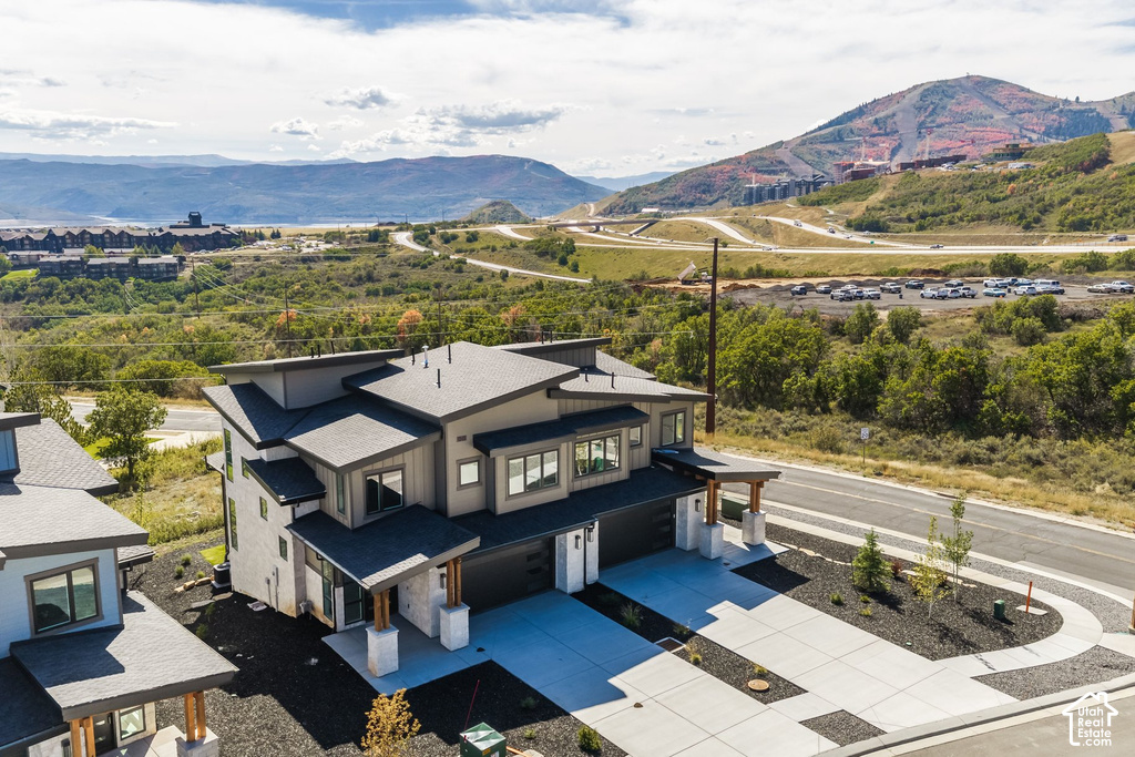 Modern exterior with multi-level roofline, large windows, and an expansive concrete driveway