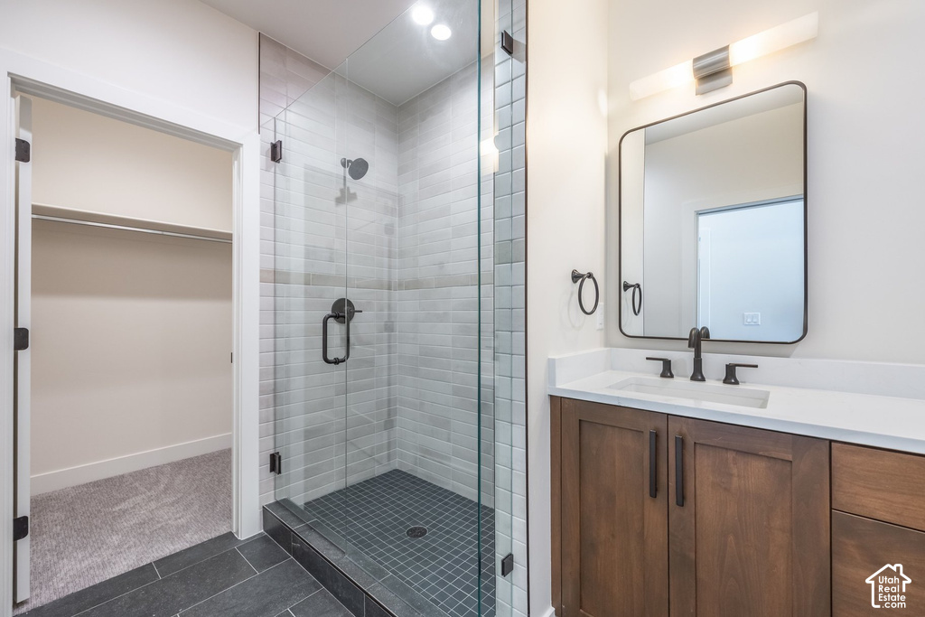 Glass-enclosed shower with subway tile surround, dark tile shower pan, and matte black fixtures