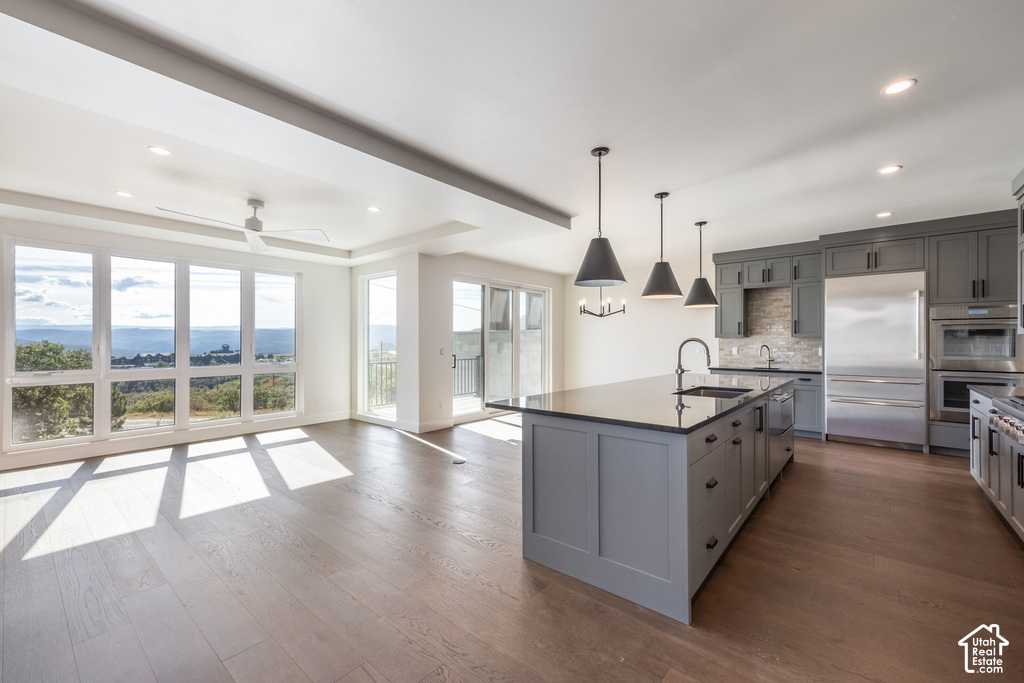 Expansive wood-finish flooring throughout, complemented by recessed lighting and a ceiling fan