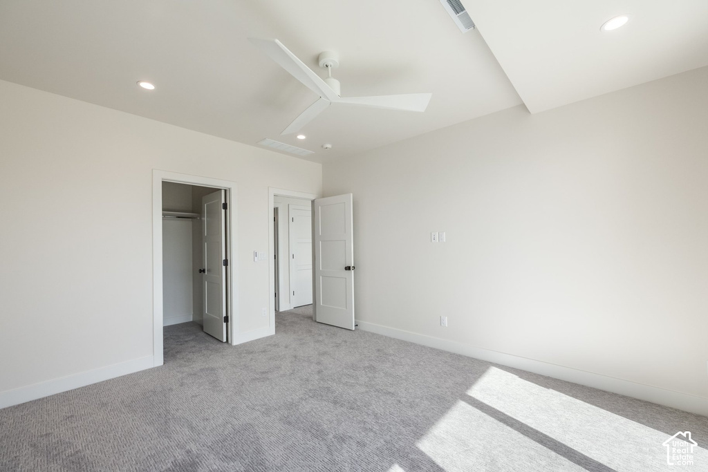 Recessed lighting, ceiling fan, white paneled doors with matte black hardware, and neutral carpet flooring