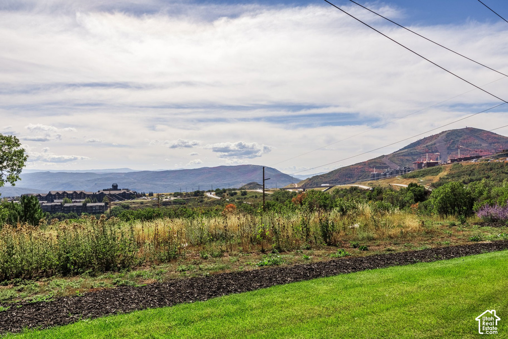 Expansive landscape featuring distant mountains and a partial view of a large building structure