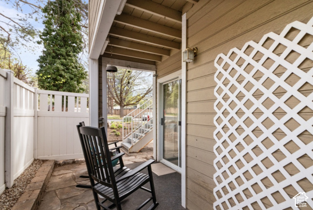 Patio with flagstone flooring, white privacy fencing, and a sliding glass door entry