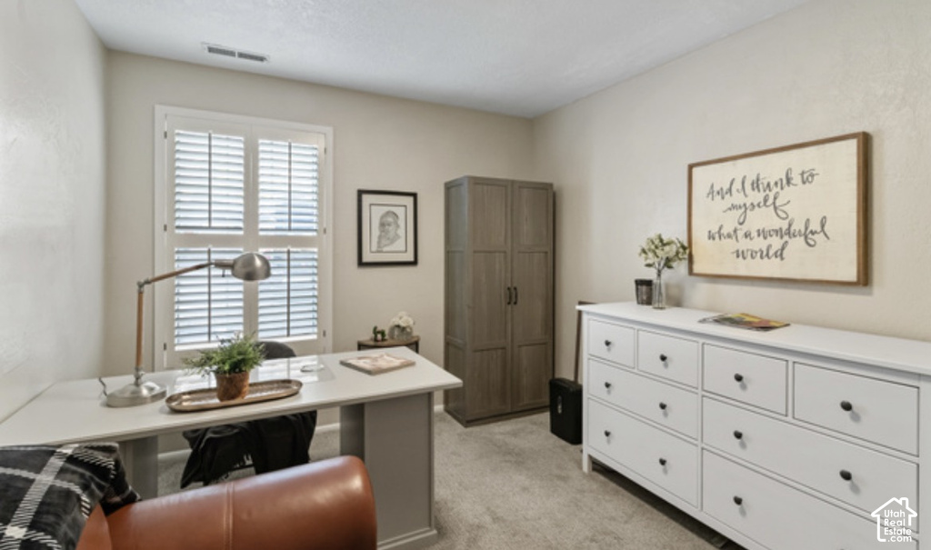 Window with louvered shutters, light beige wall paint, built-in wardrobe, and carpeted flooring