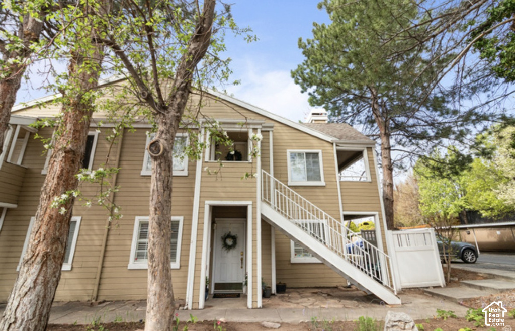 Multi-story exterior with horizontal siding, white trim, and a prominent exterior staircase