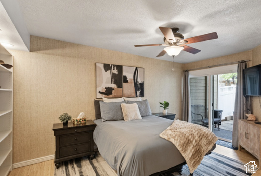 Built-in shelving, ceiling fan with integrated lighting, sliding glass door, and wood-finish flooring