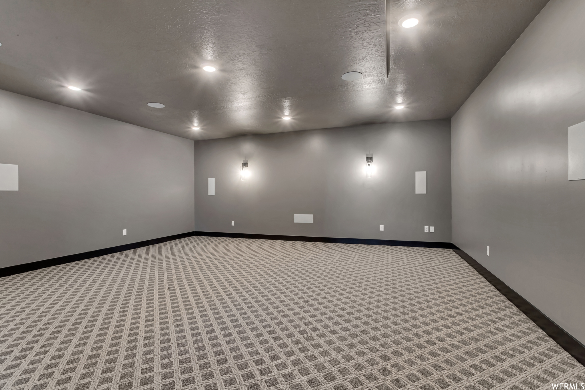 This theater features dark walls and ceiling, an upgraded theater package and fun flooring
