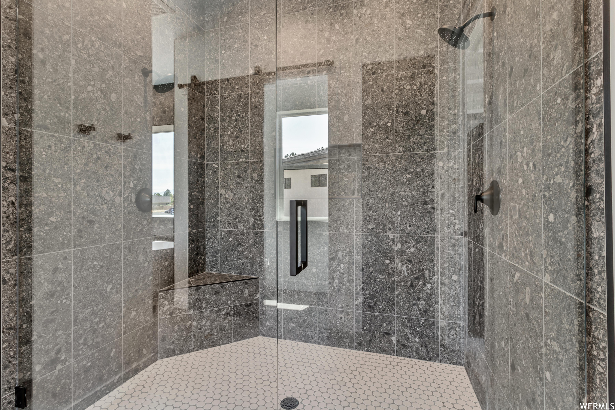 Full glass fronts open the shower to show off exquisite tile work