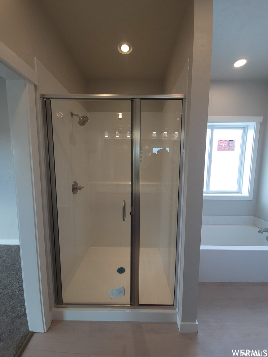 Bathroom featuring natural light and separate shower and tub enclosures