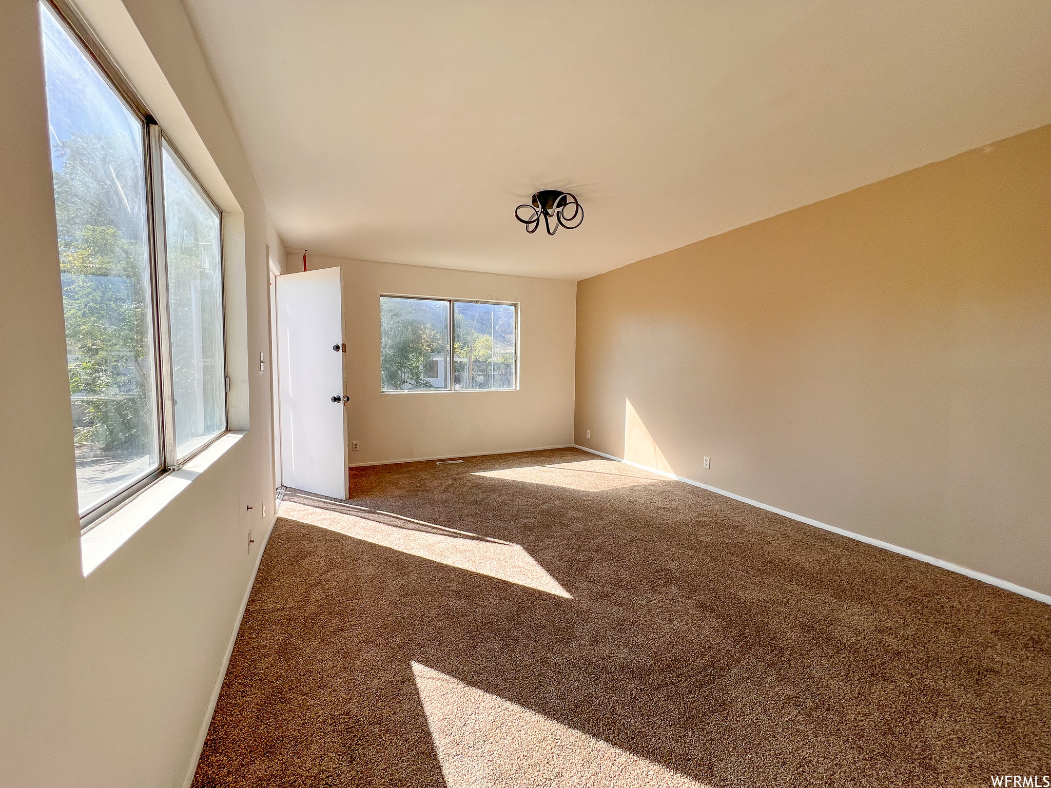 Empty room with carpet and natural light