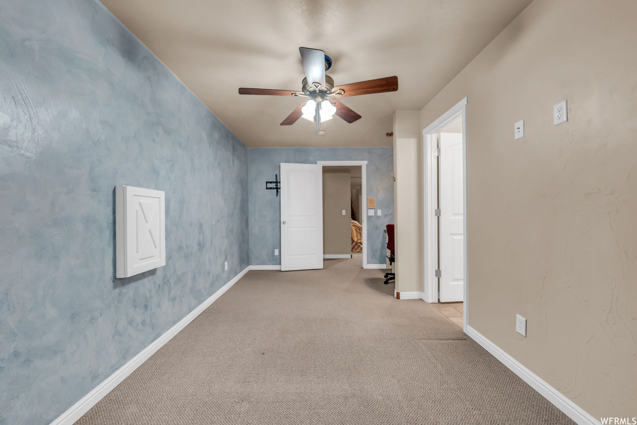 Carpeted empty room with a ceiling fan