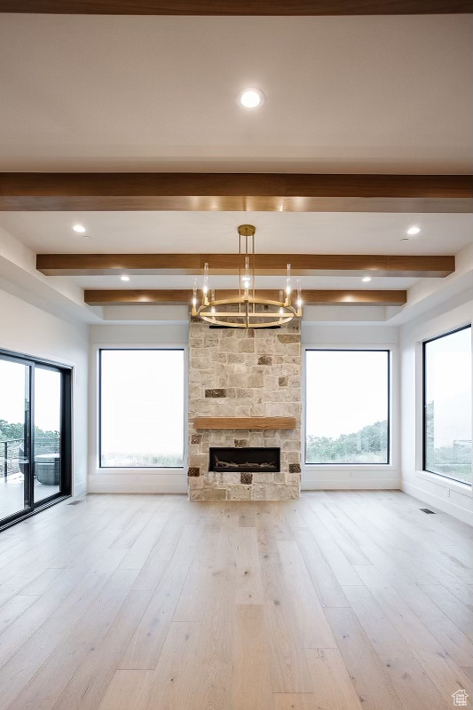 Great room featuring beamed ceiling, a notable chandelier, and light hardwood / wood-style flooring
