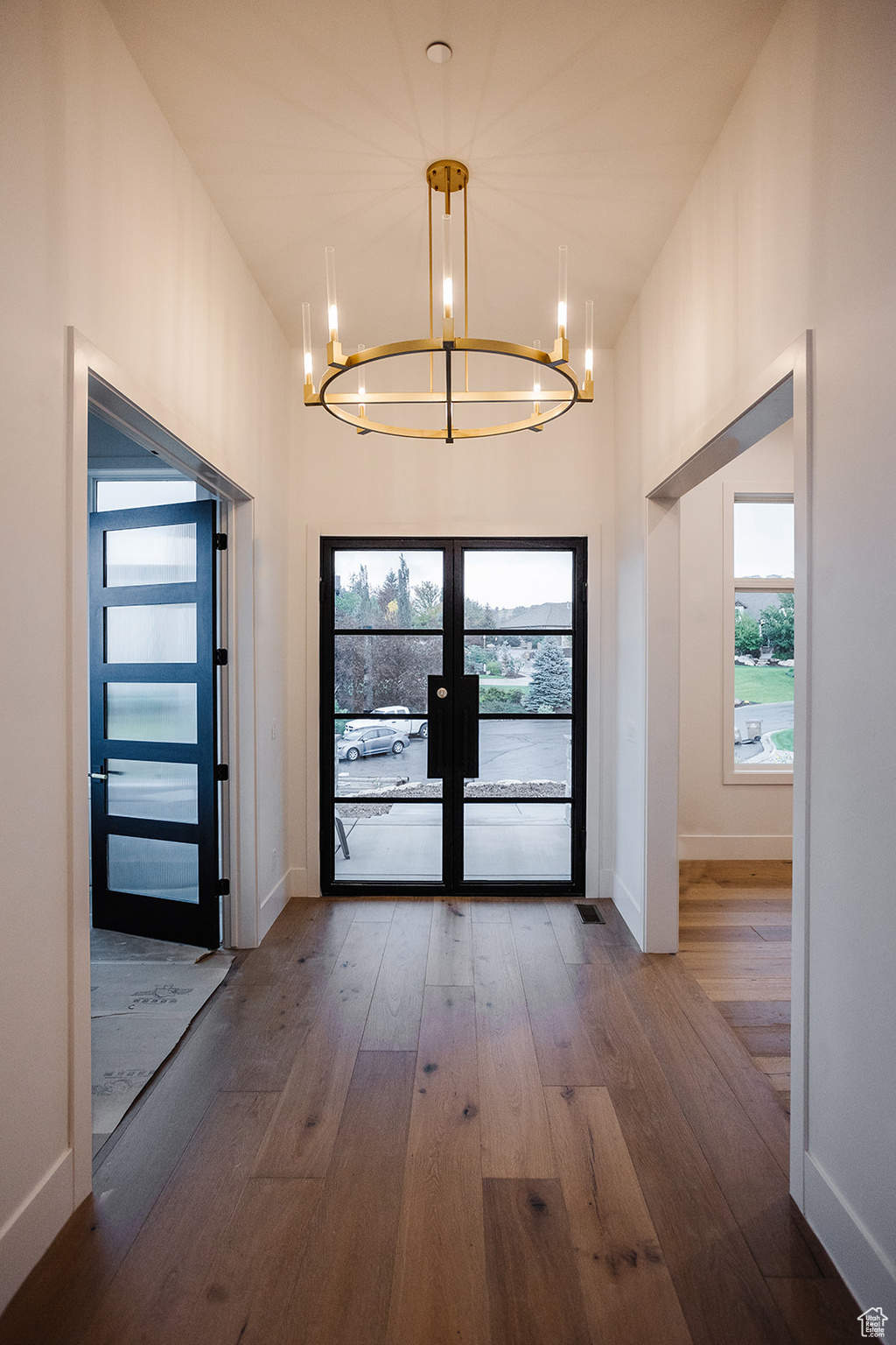 Doorway to outside with hardwood / wood-style floors, a chandelier, and french doors