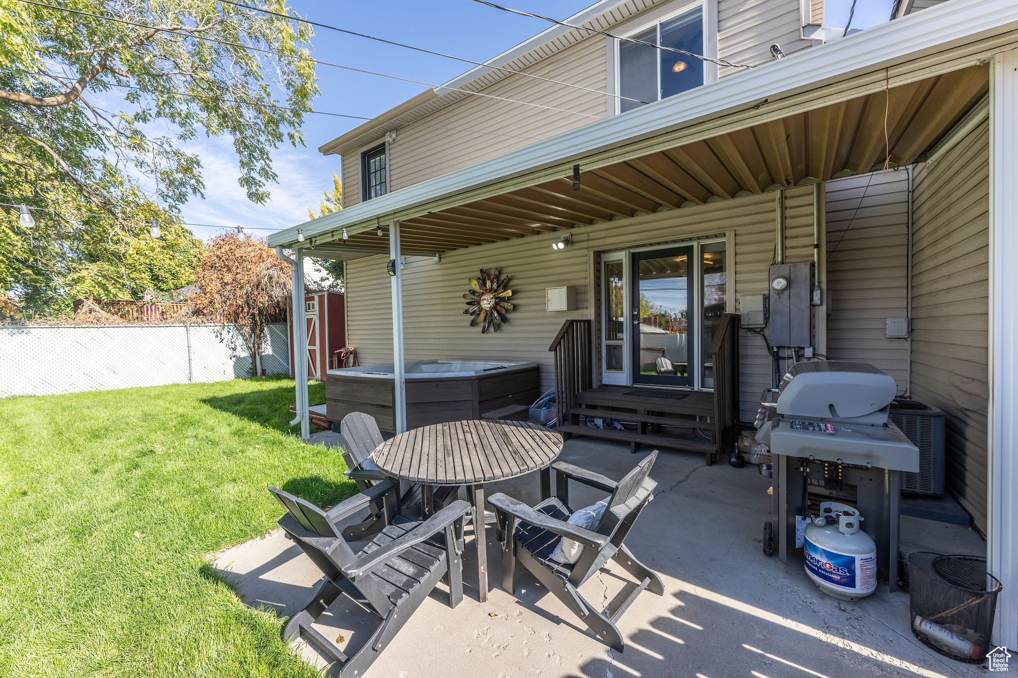 View of patio featuring area for grilling, central AC, and a hot tub