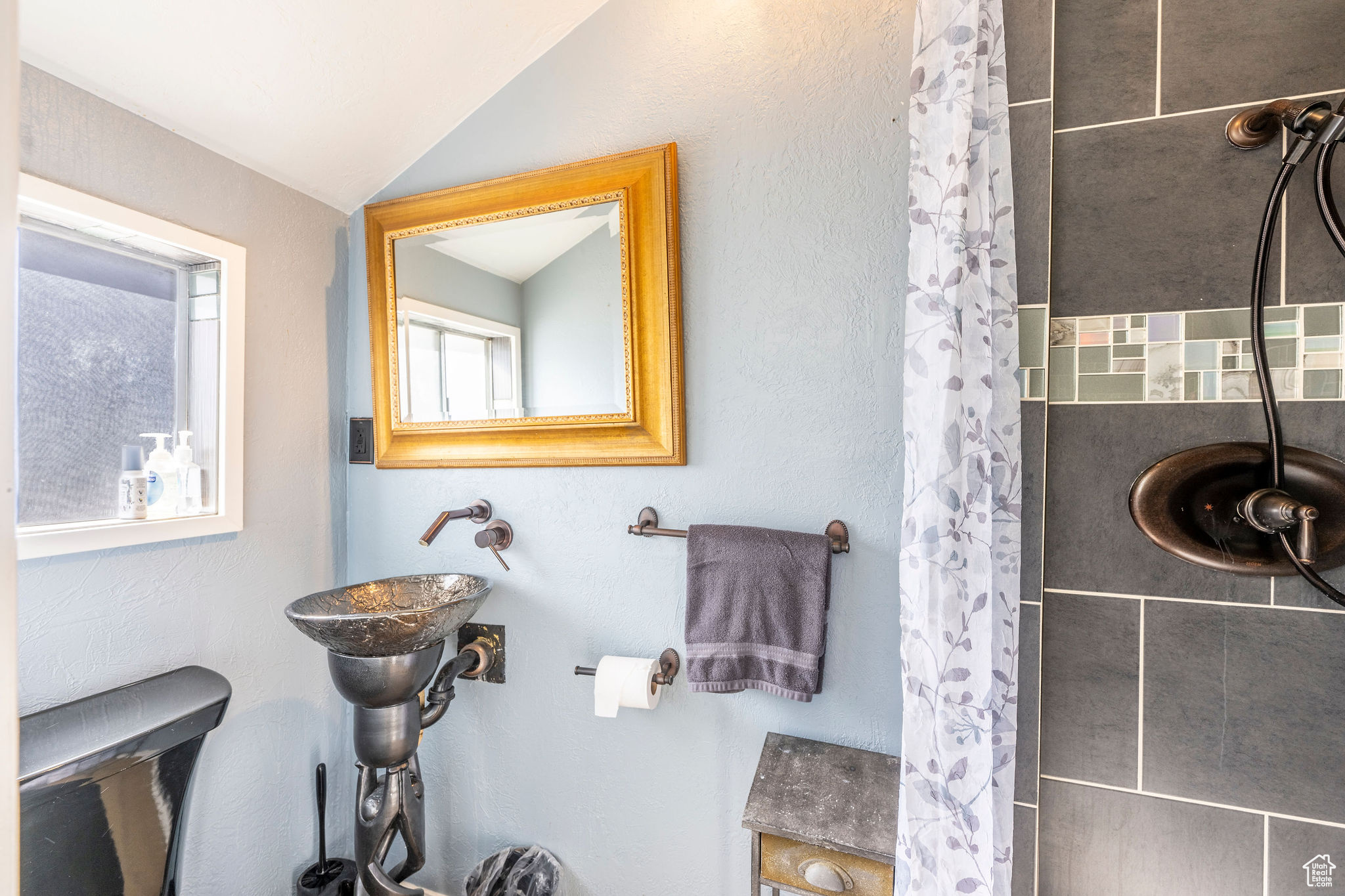 Bathroom with sink, toilet, vaulted ceiling, and a shower with curtain