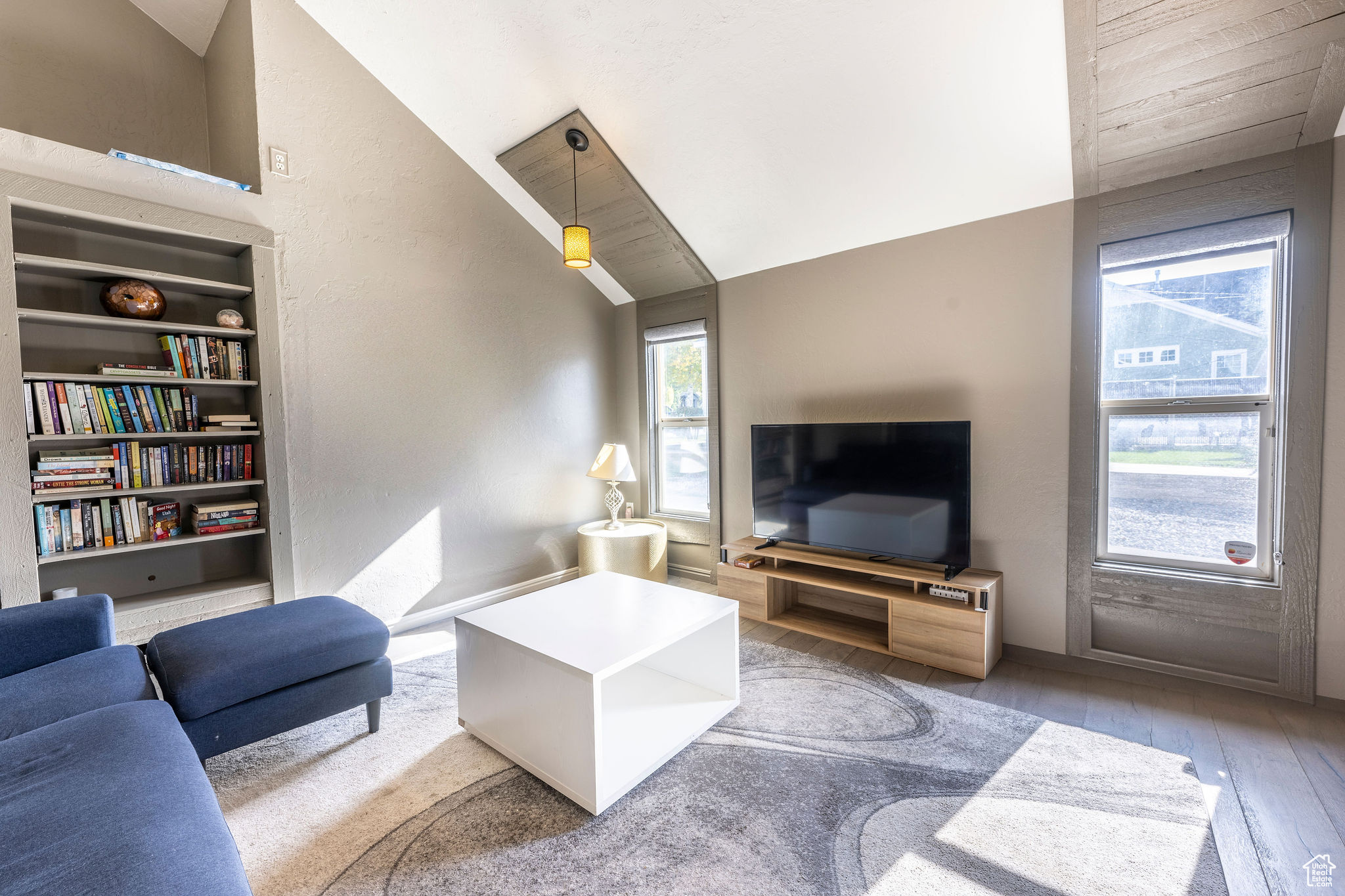 Living room featuring built in features, lofted ceiling, wood-type flooring, and wooden ceiling