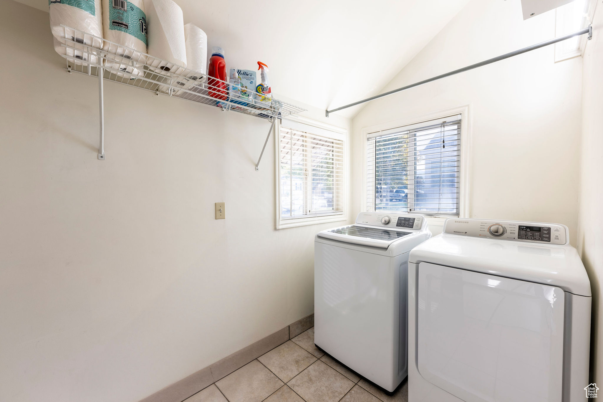 Laundry room with washing machine and dryer and light tile patterned floors