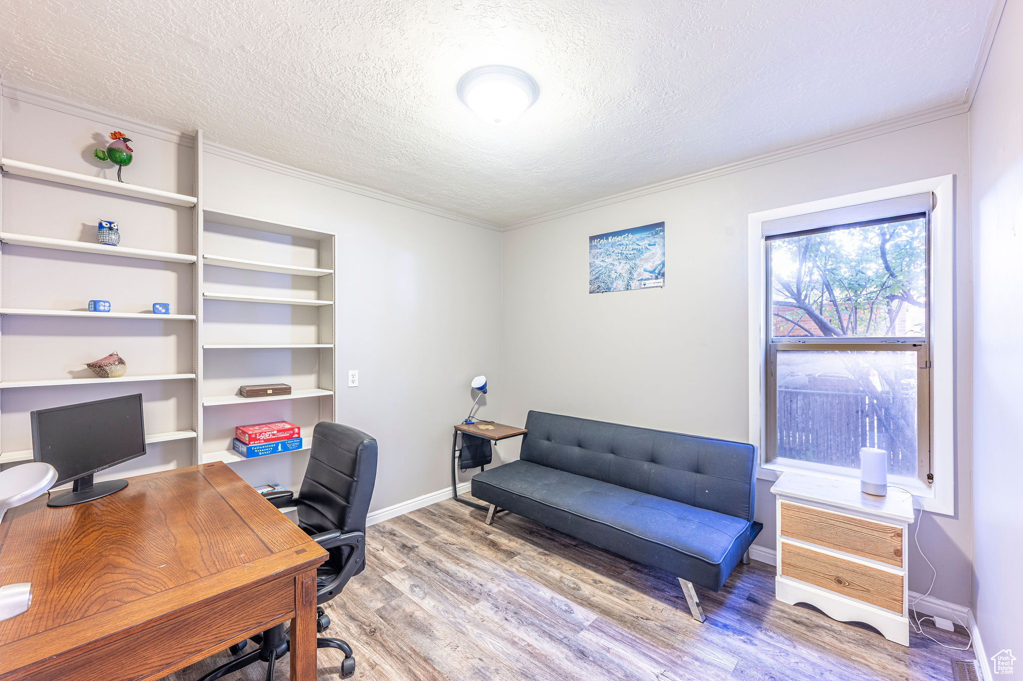 Office featuring light hardwood / wood-style floors, a textured ceiling, and crown molding