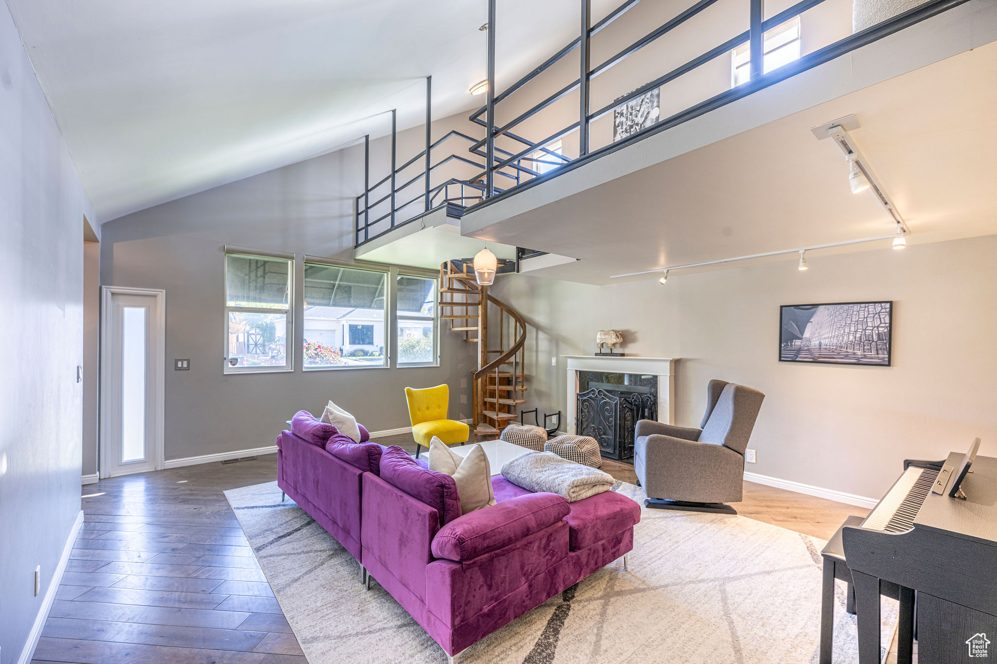 Living room featuring high vaulted ceiling, wood-type flooring, and track lighting