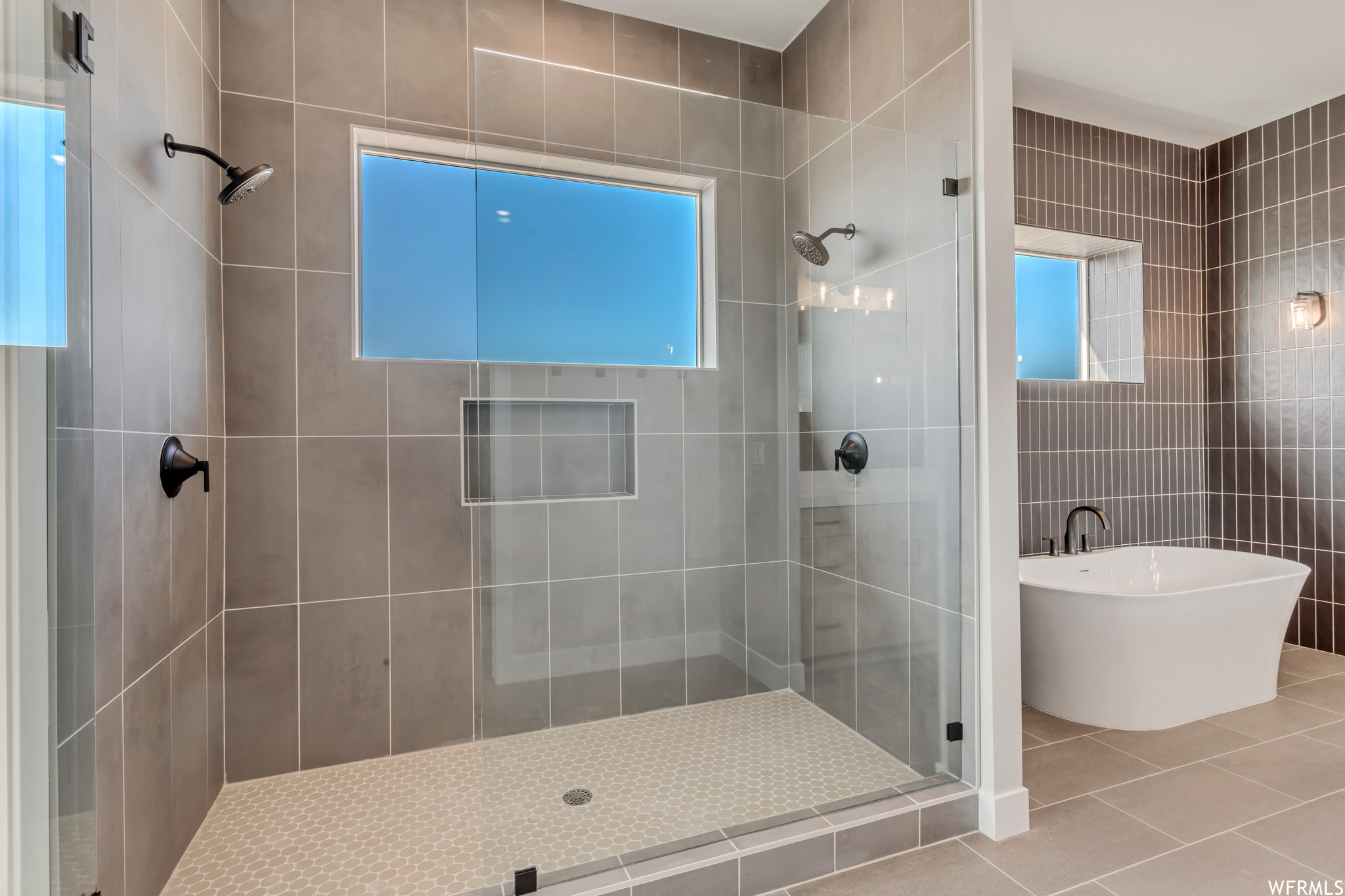 Step in shower with dual shower heads and storage niche for bath products, an optional rain shower and bench can be added