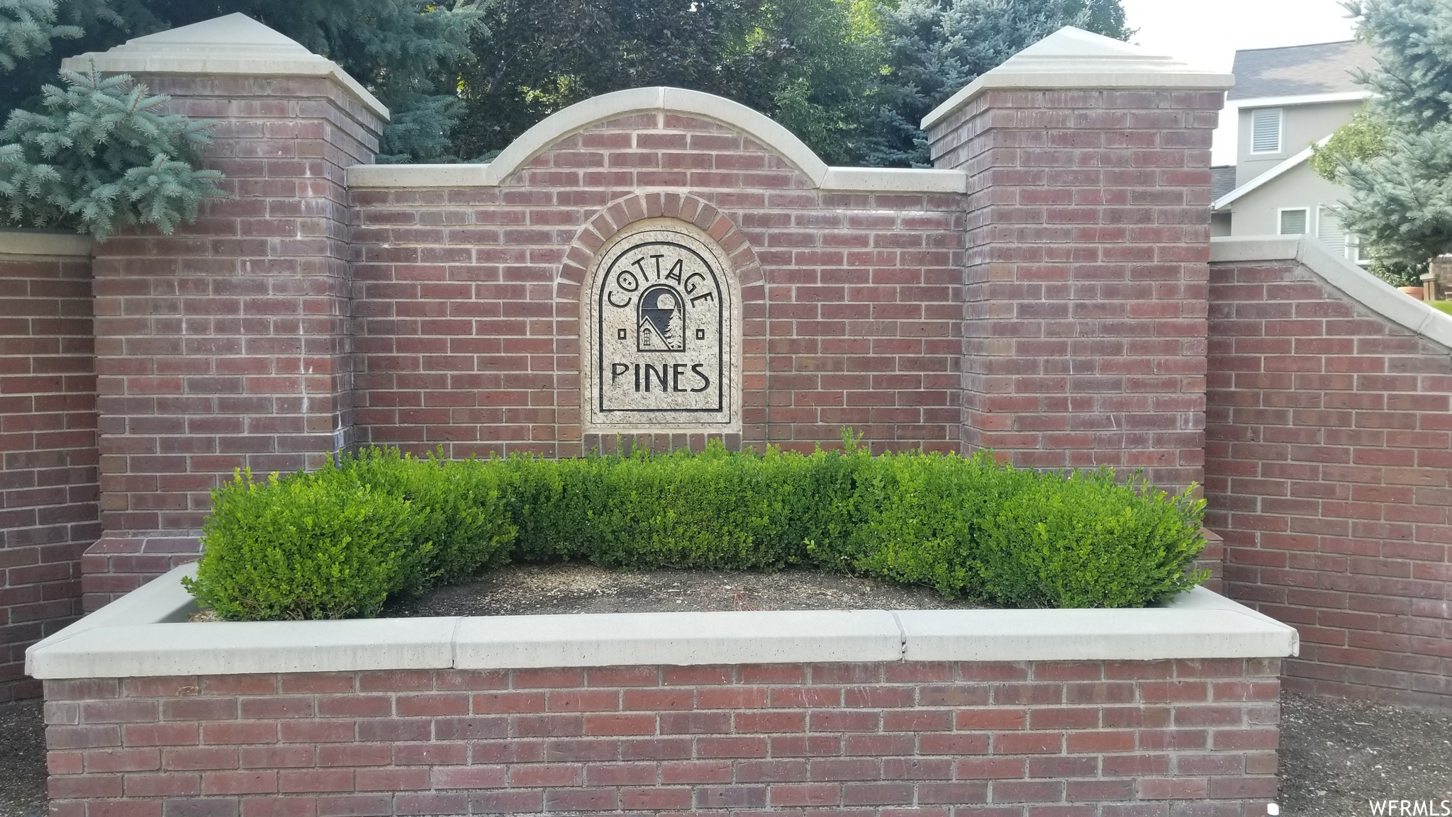 Brick planter boxes are on each side of the gate.