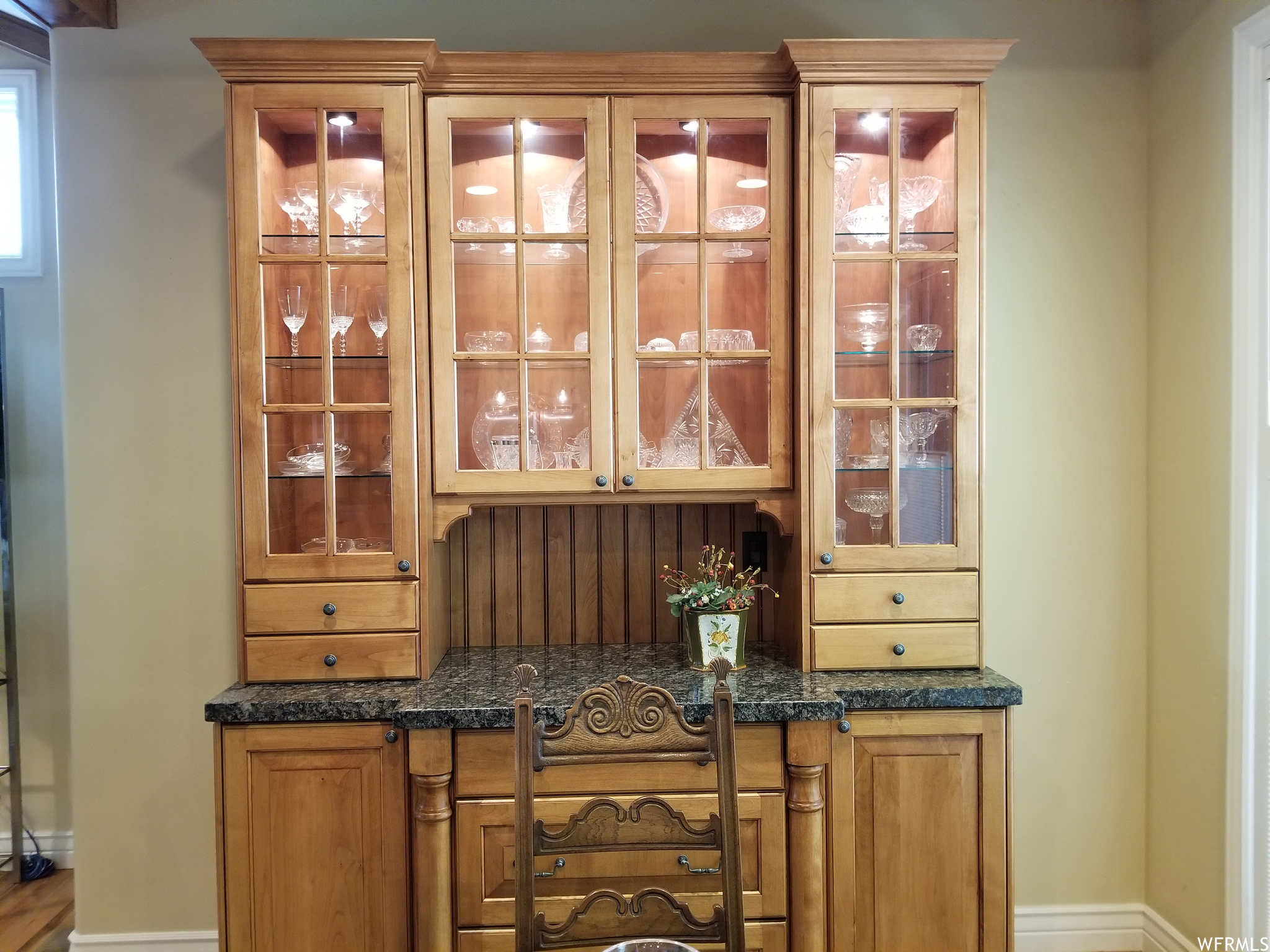: The lighted built in hutch has a granite countertop and drawers and shelving for all your fine collectibles.