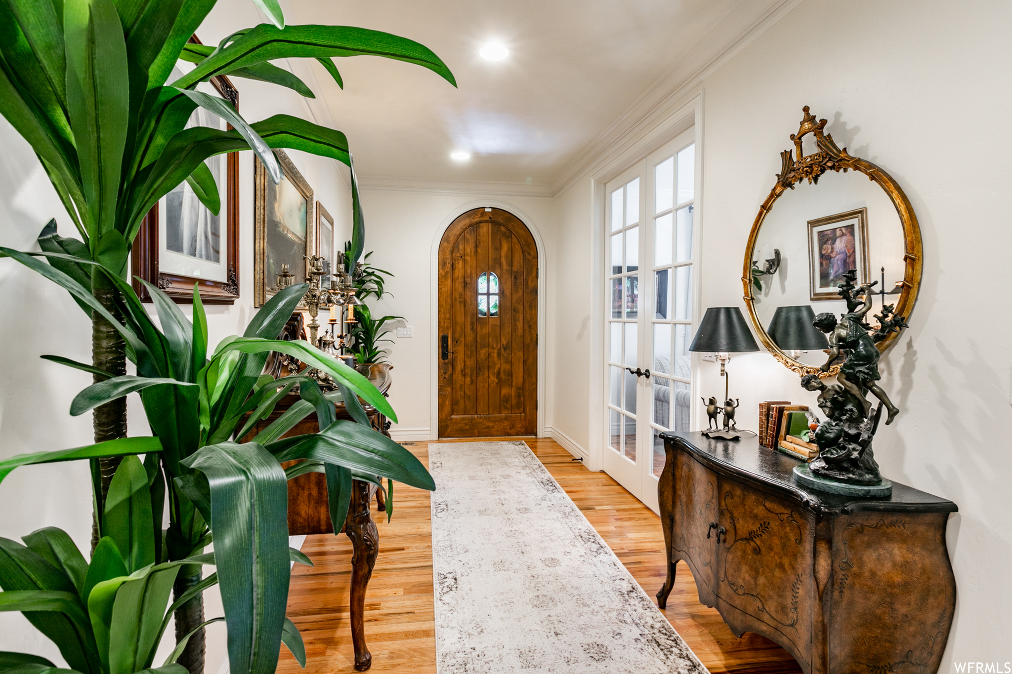 Welcome your guests into this beautiful entry with deep moldings and French doors that open to the formal living room.