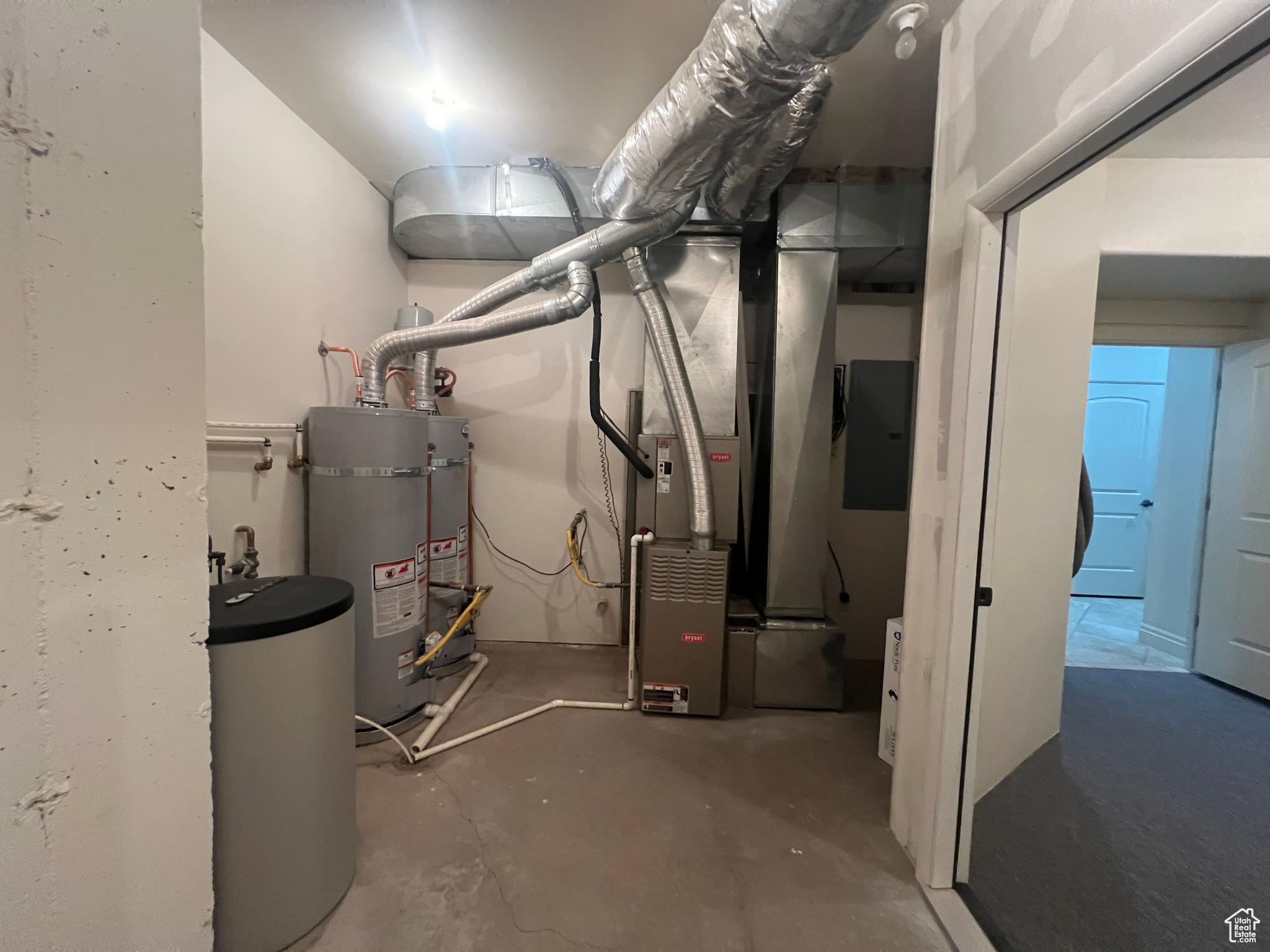 Utility room featuring strapped water heater