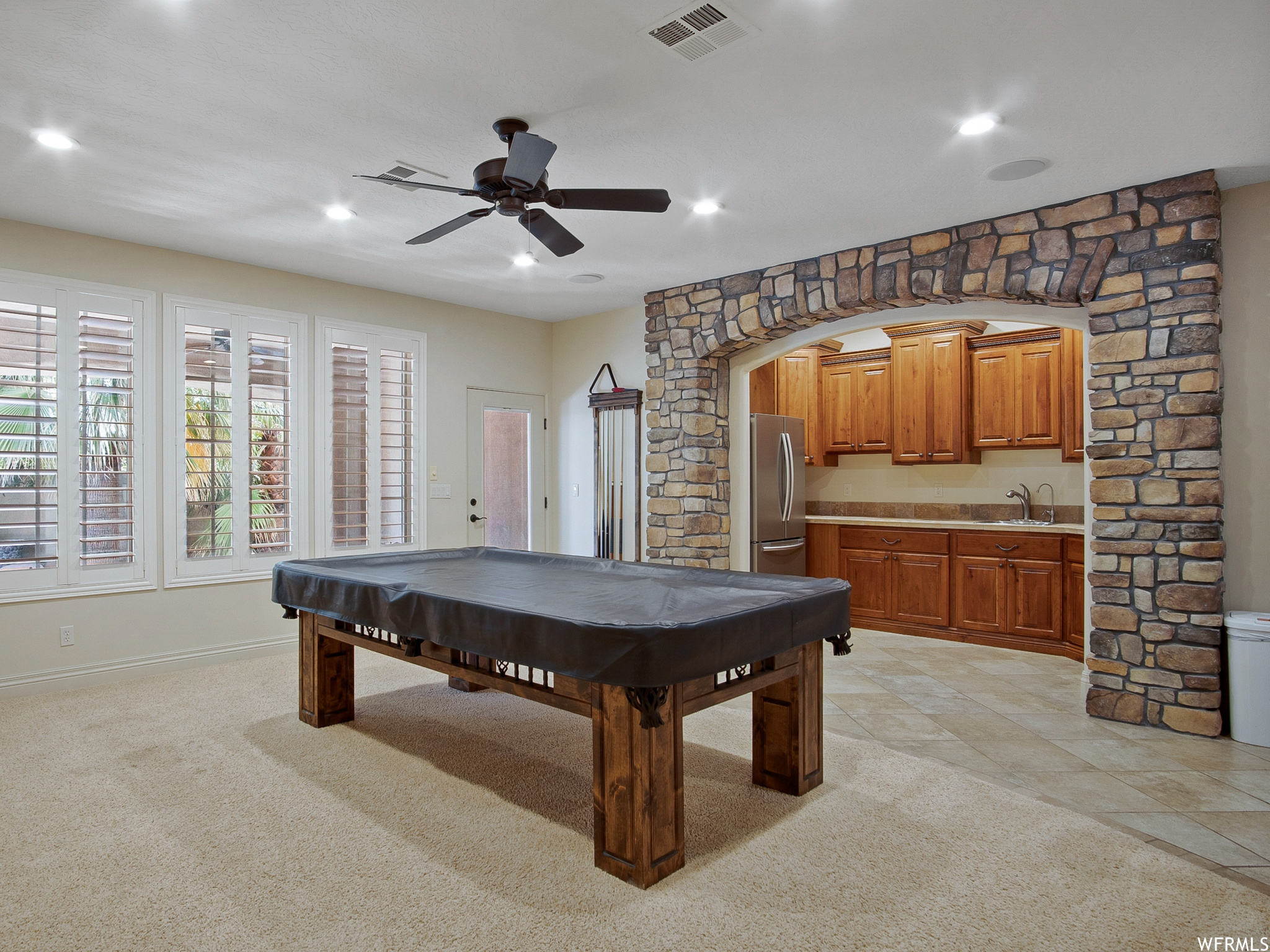 Playroom with a ceiling fan, tile floors, and natural light