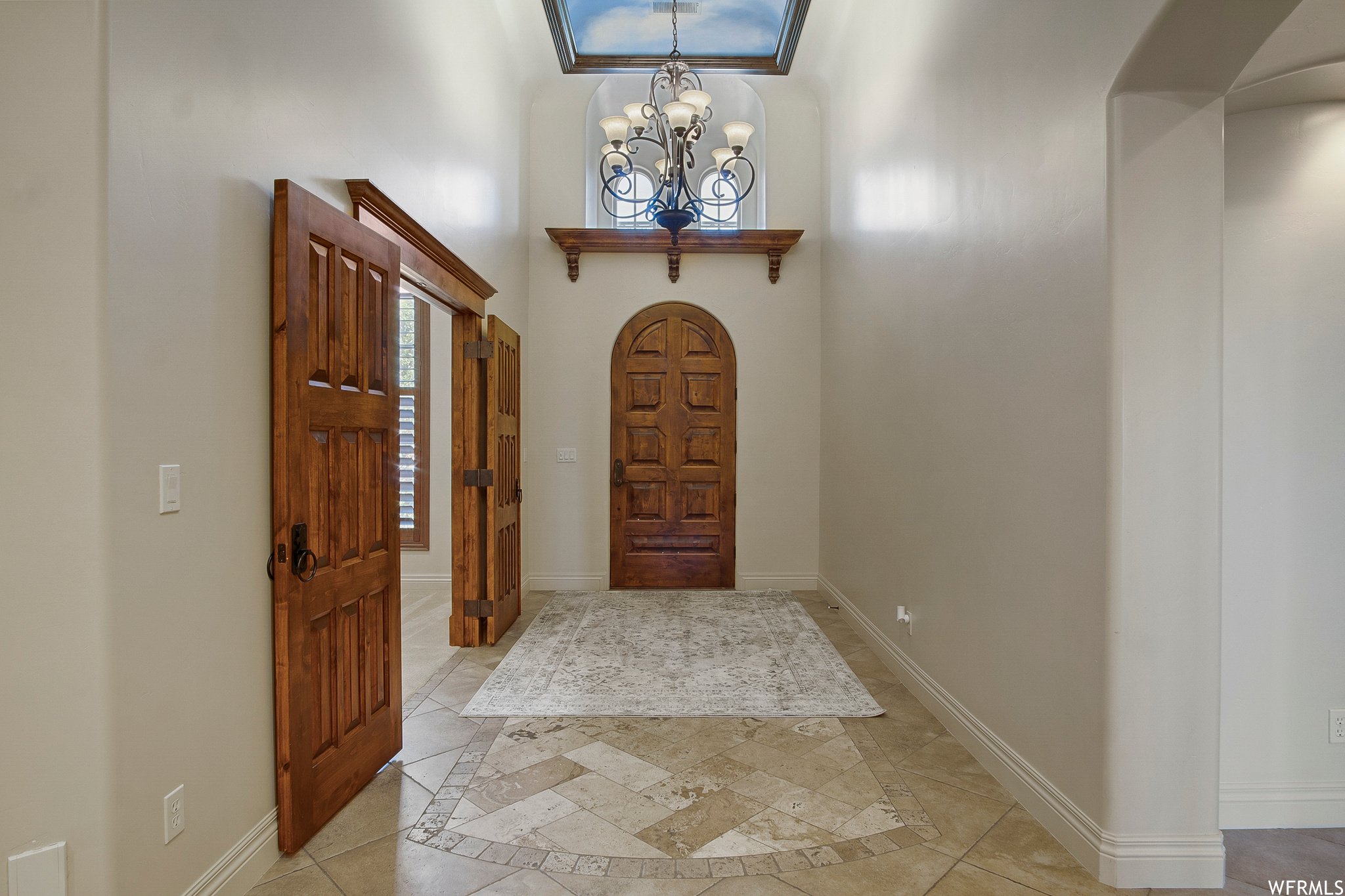 Foyer featuring tile flooring and a notable chandelier