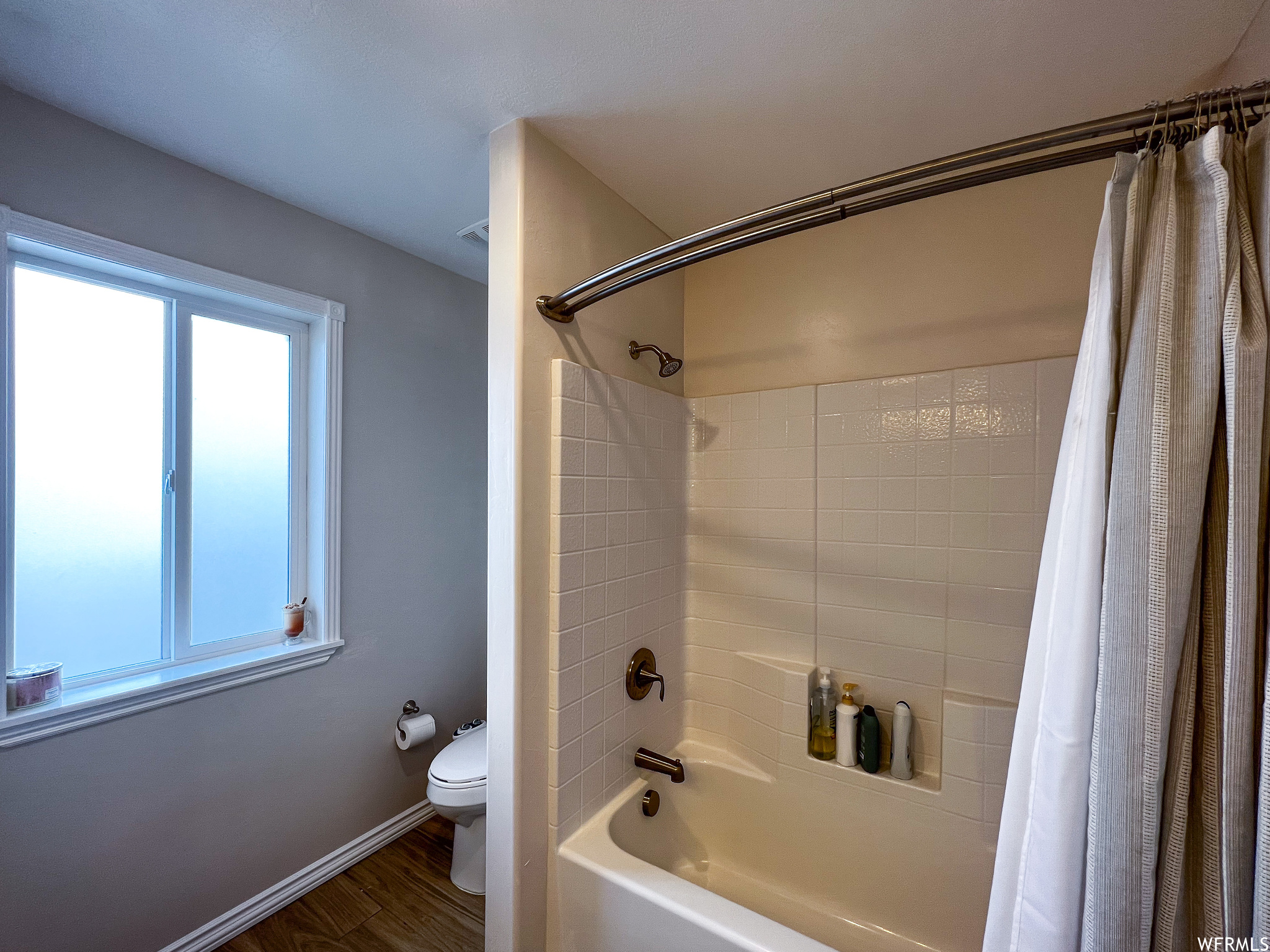 Bathroom featuring shower / washtub combination and toilet