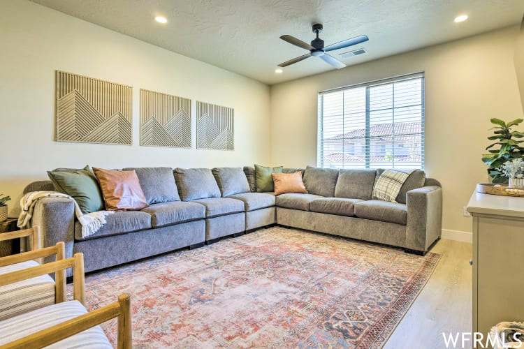 Living room featuring Luxury Vinyl flooring, natural light, and a ceiling fan