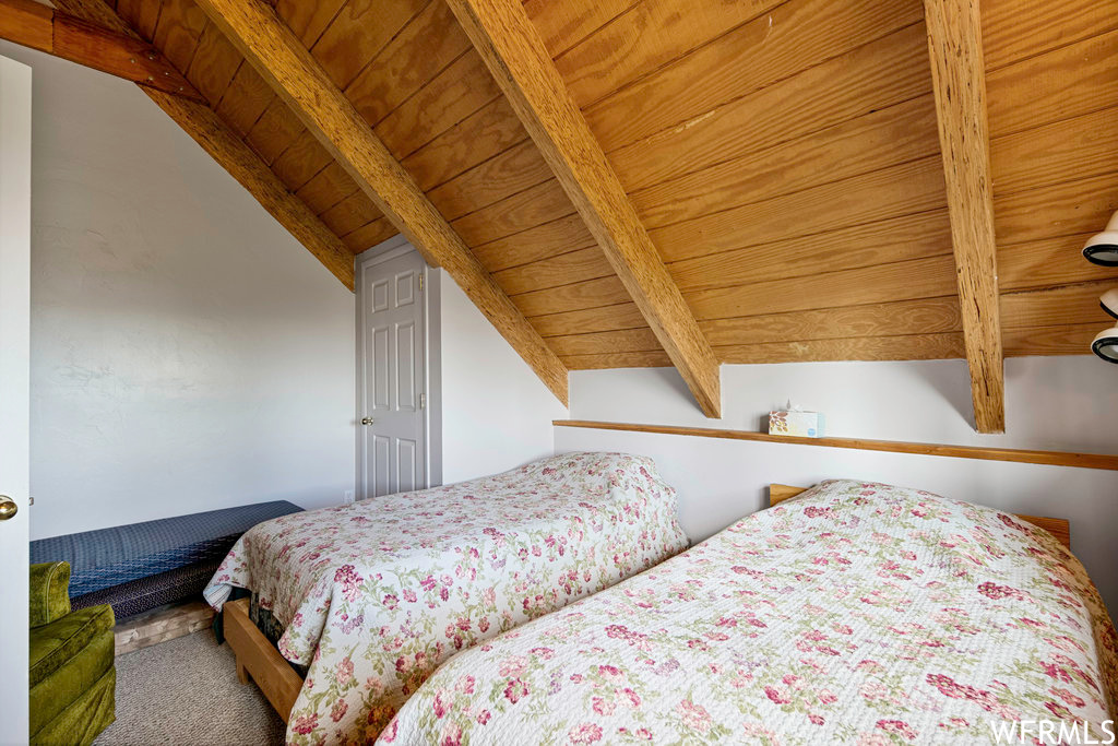 Bedroom featuring vaulted ceiling with beams