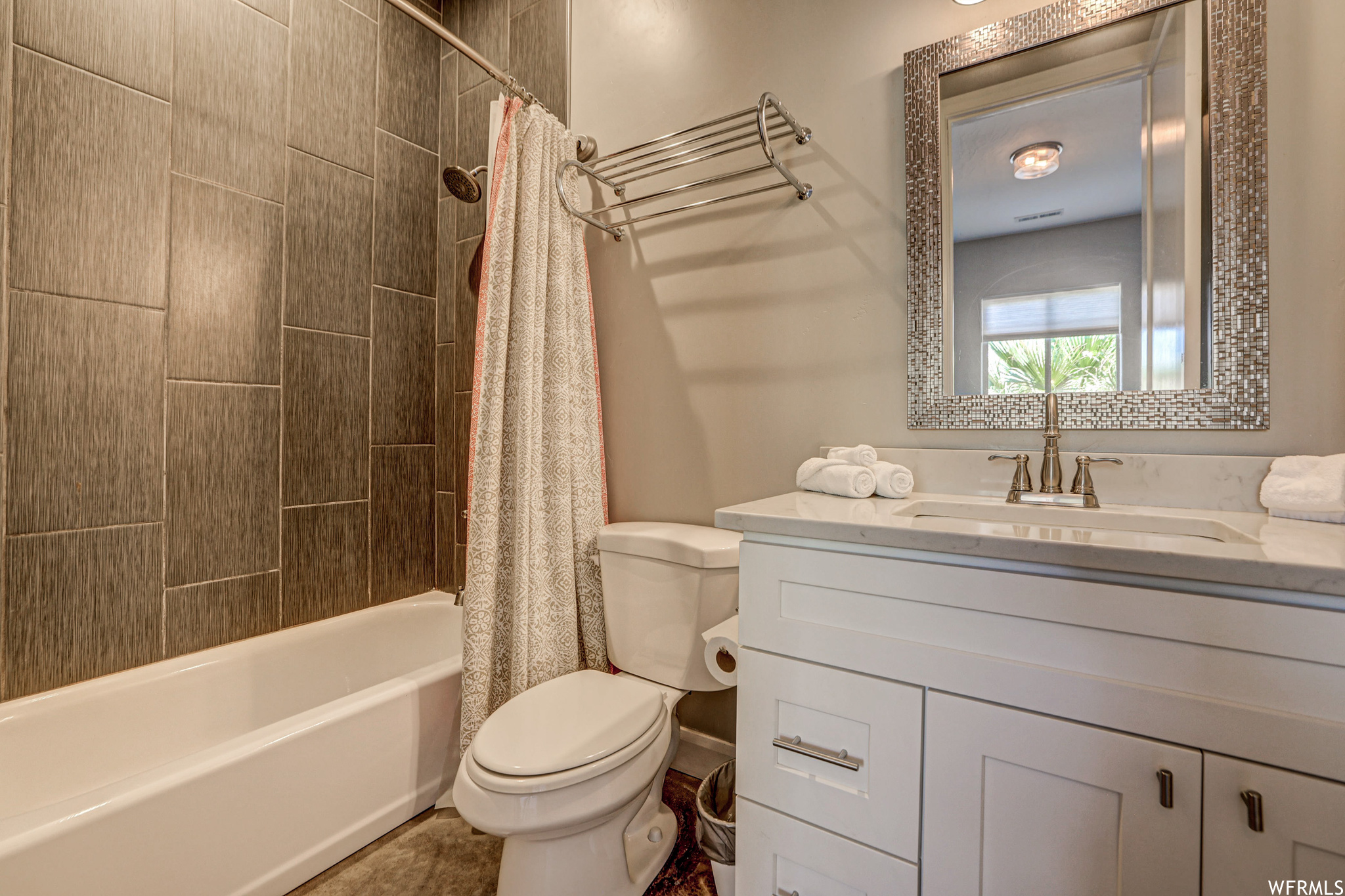 Full bathroom featuring tile floors, shower / bathtub combination, shower curtain, mirror, toilet, and vanity