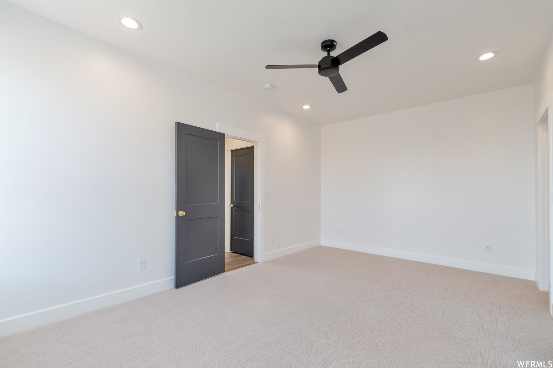 Spare room featuring a ceiling fan and carpet