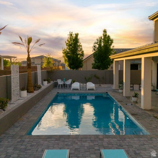Pool at dusk with a patio area