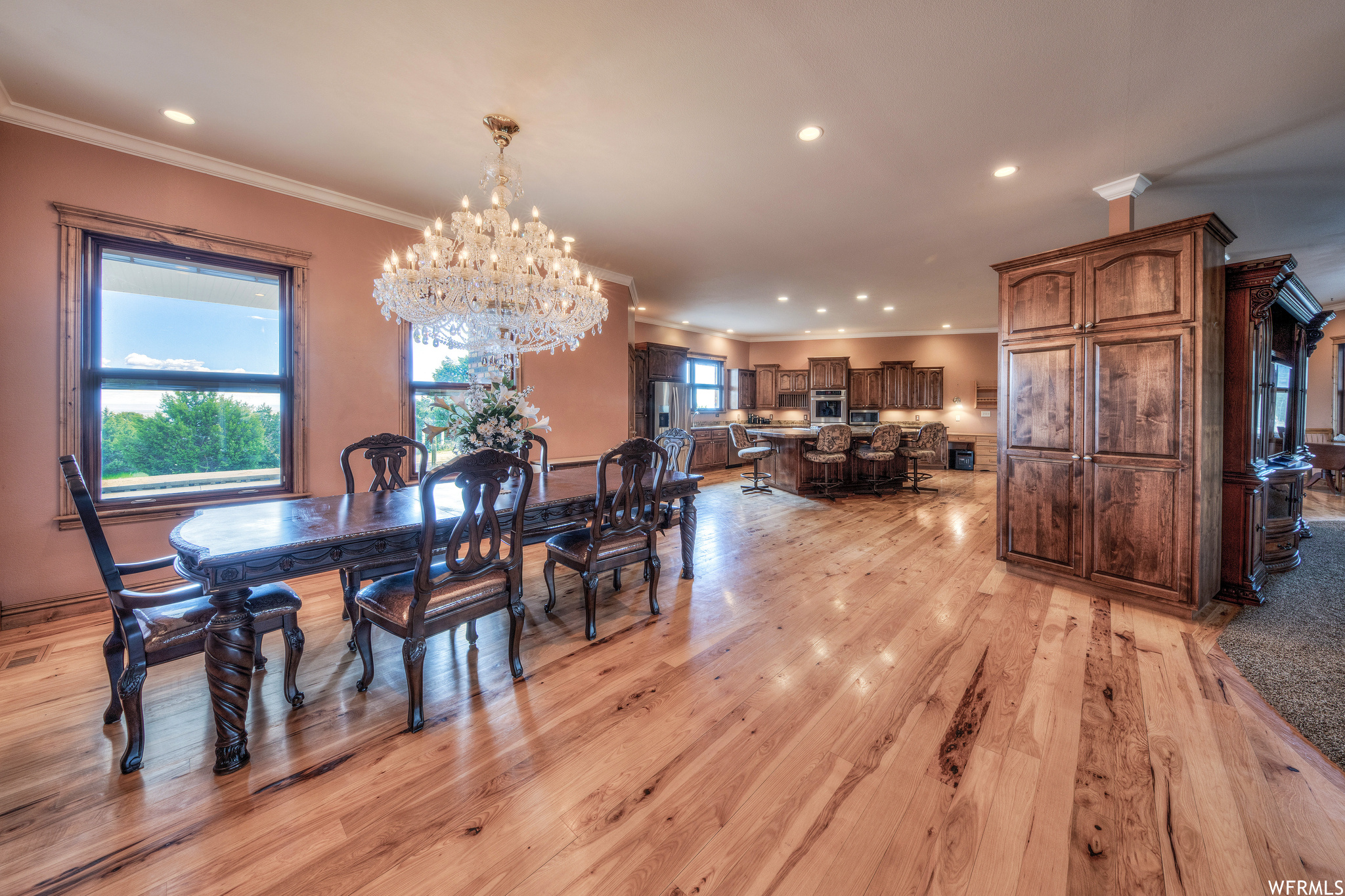 Hardwood floored dining area featuring natural light and a notable chandelier