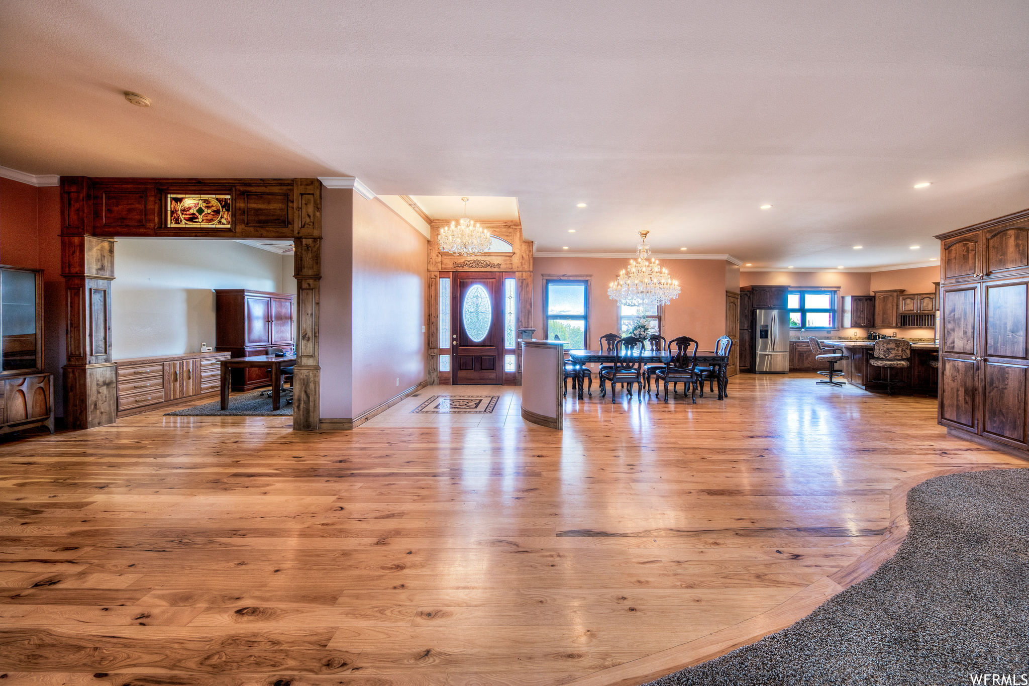 Living room featuring hardwood floors, natural light, and a notable chandelier