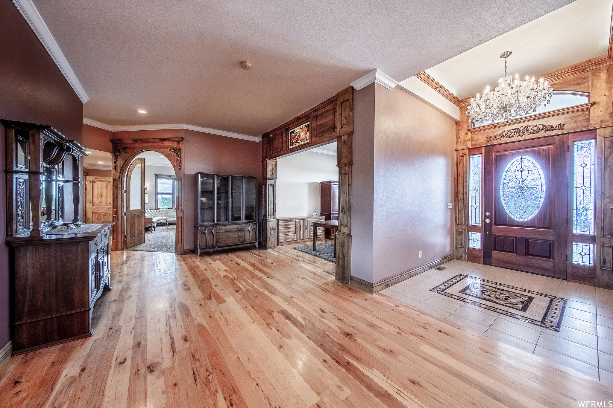 Wood floored entrance foyer featuring a chandelier and natural light