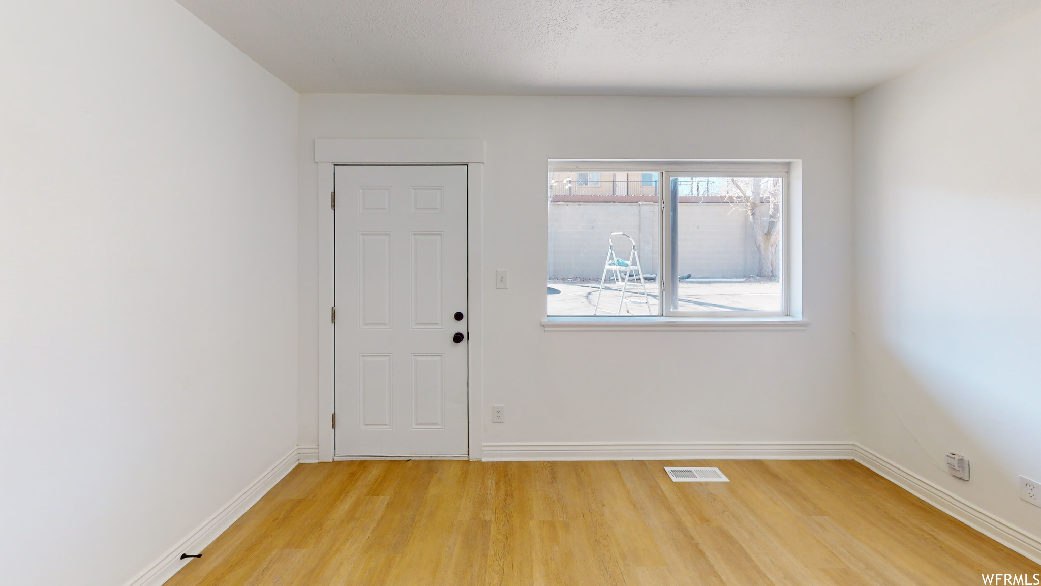 back 6 units (4,5,6,7,8,9). Hardwood floored empty room featuring natural light