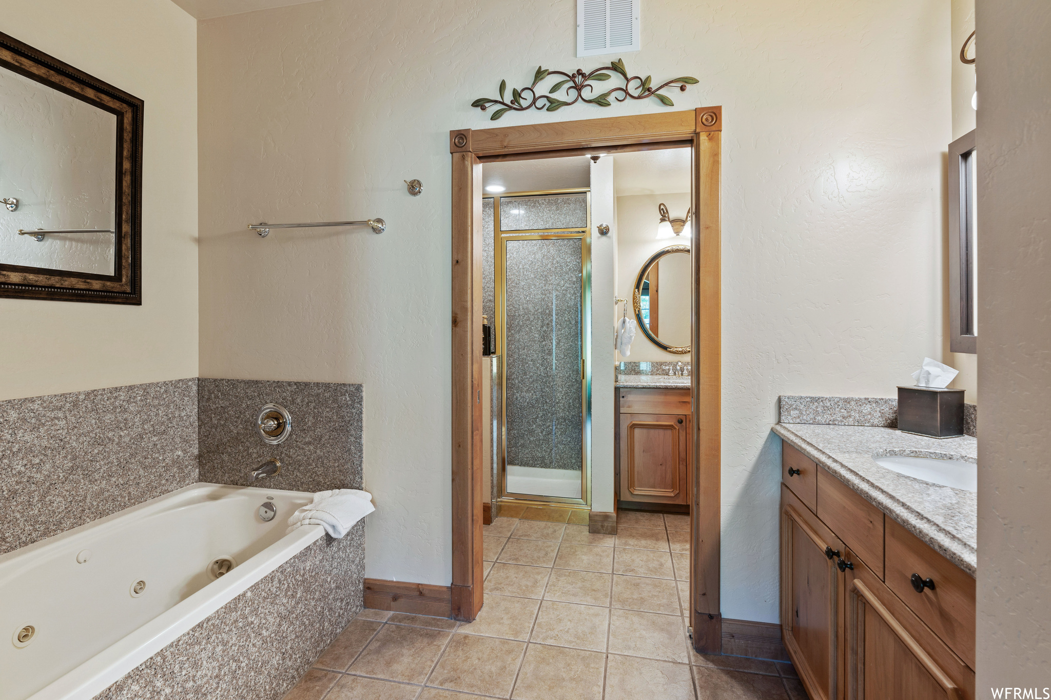 Bathroom with tile floors, separate shower and tub, and vanity