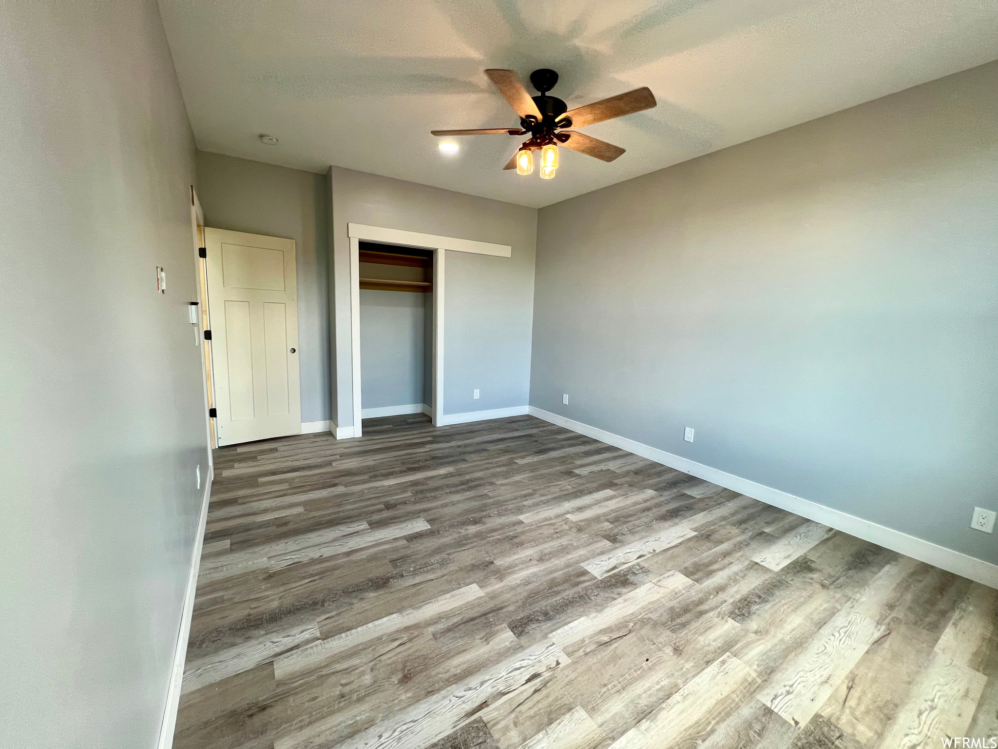 Hardwood floored bedroom featuring a ceiling fan