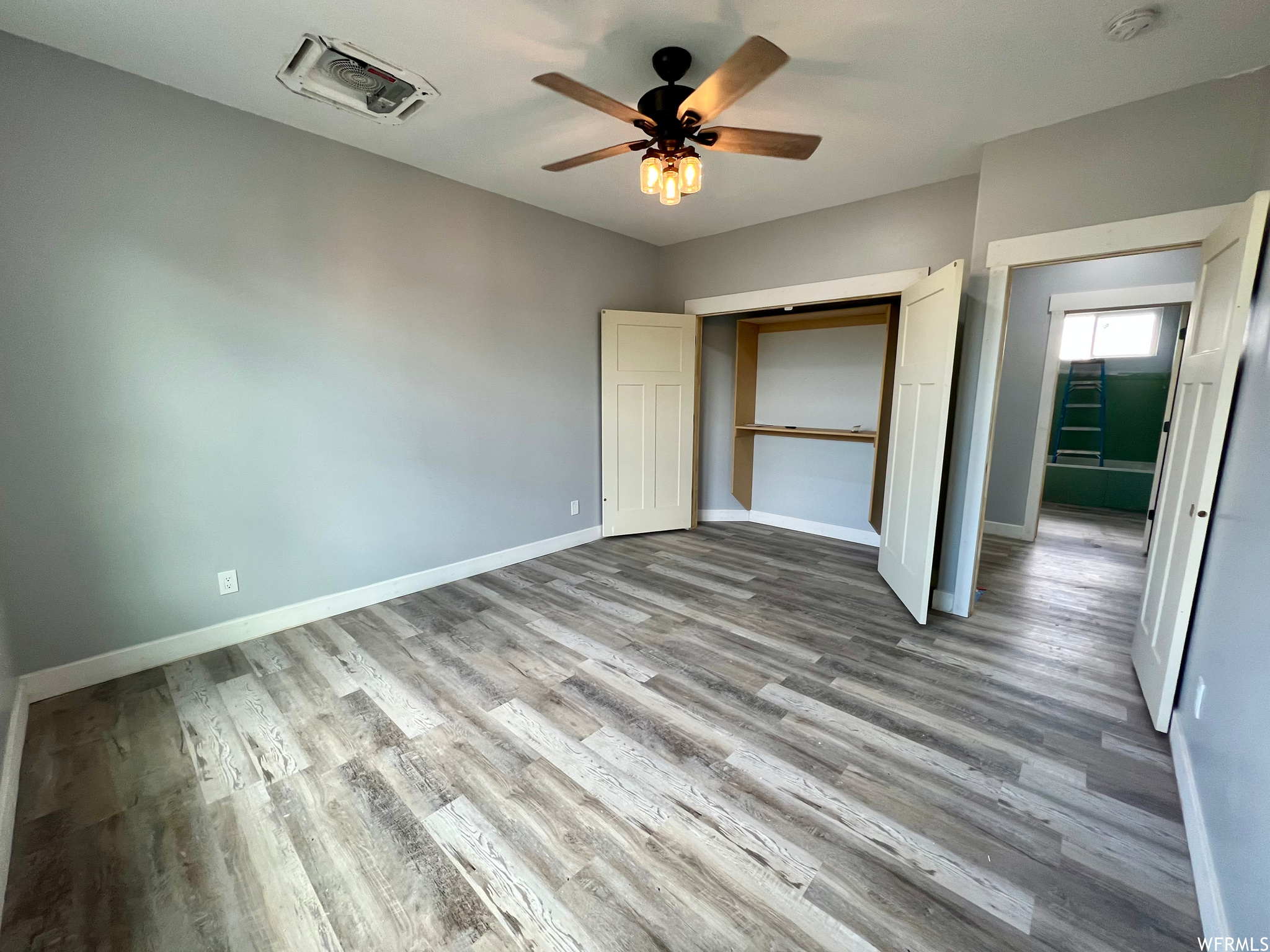 Hardwood floored bedroom featuring a ceiling fan