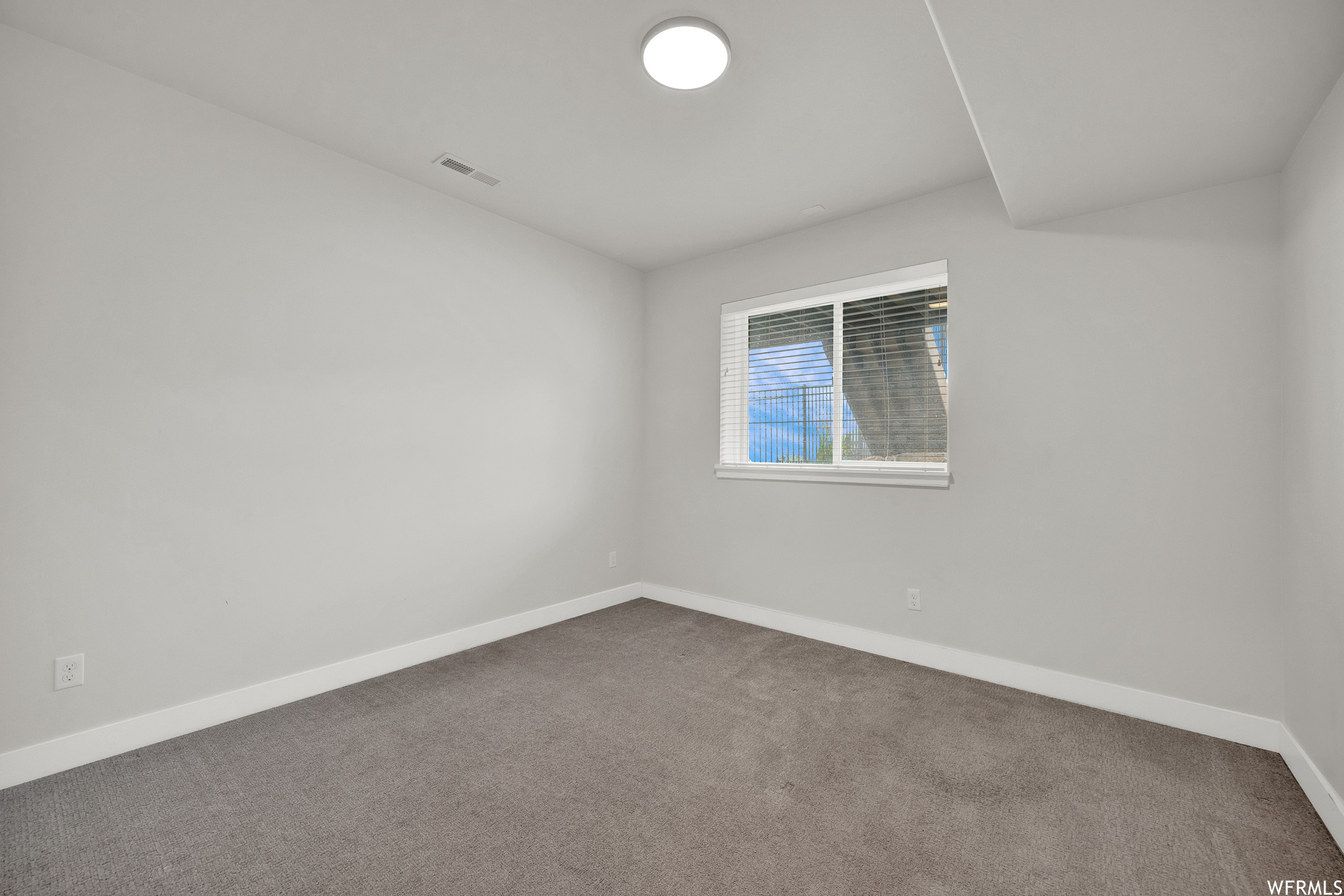 Carpeted empty room with natural light