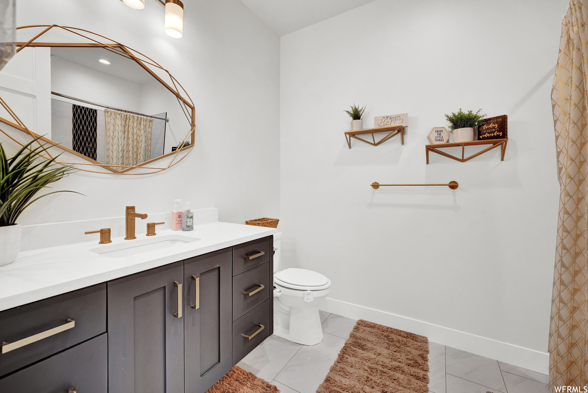 Bathroom featuring tile flooring, vanity, toilet, mirror, and shower curtain