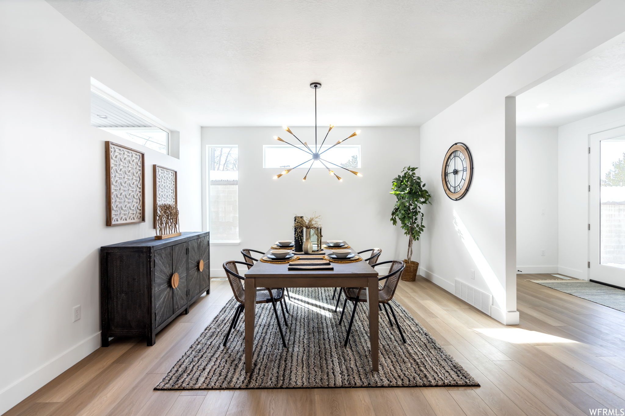 Hardwood floored dining area featuring a healthy amount of sunlight