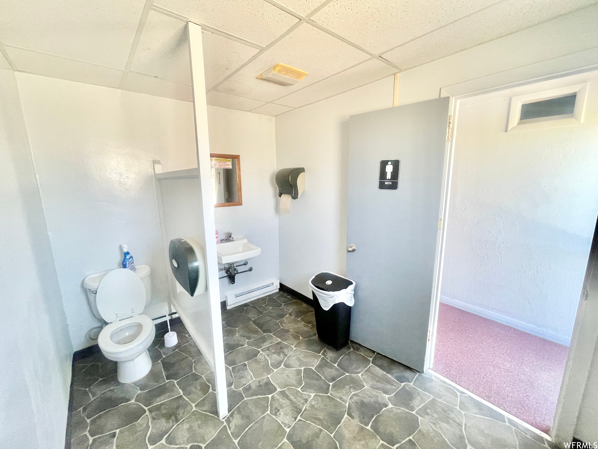 Half bathroom with tile floors, washbasin, and toilet