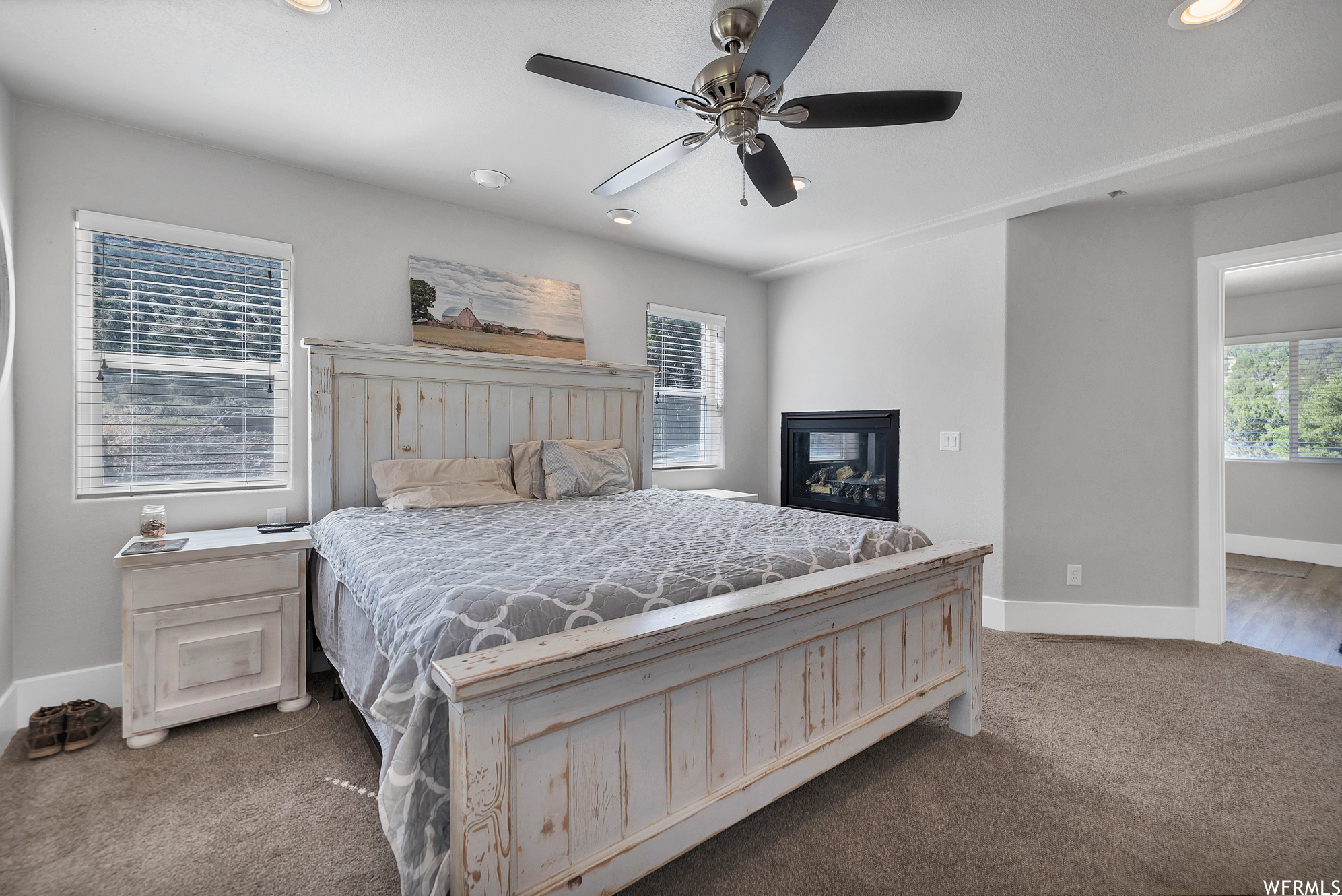 Bedroom featuring natural light, a ceiling fan, and carpet
