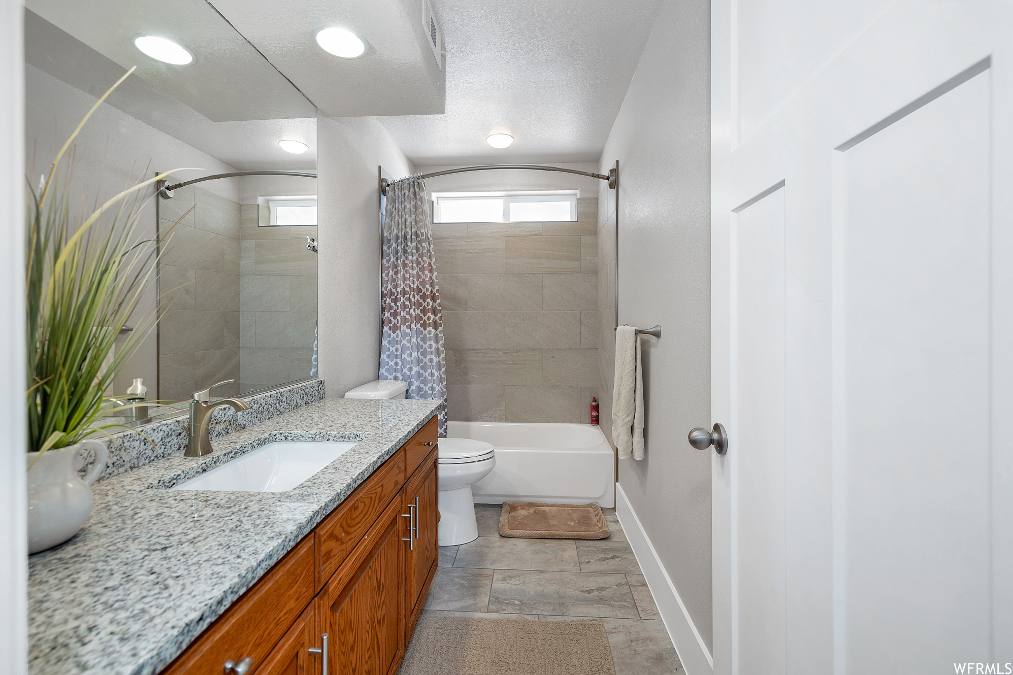 Full bathroom featuring tile flooring, vanity, mirror, shower / bathtub combination, and toilet