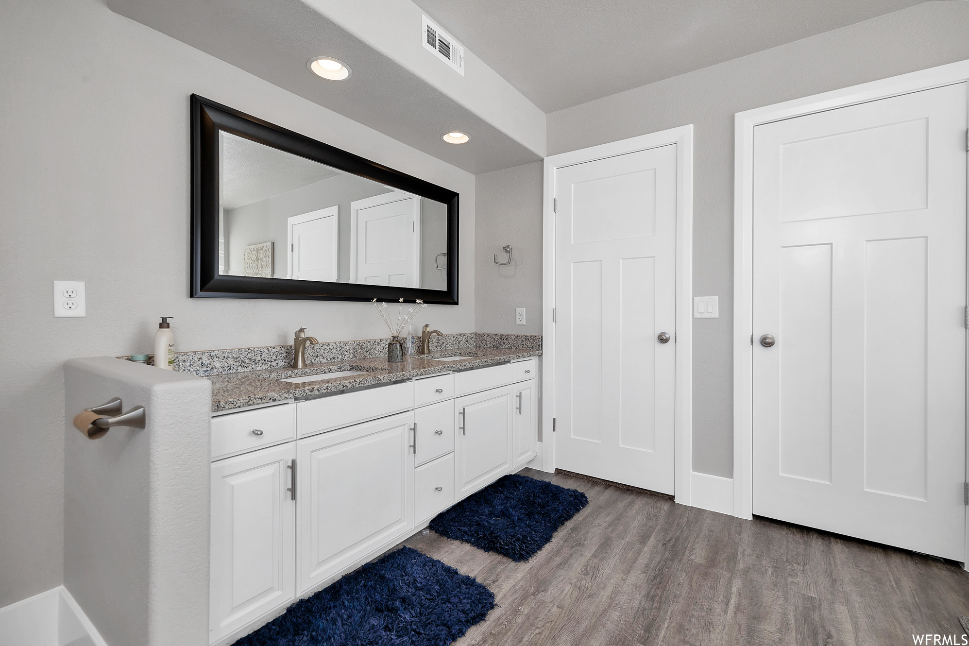 Bathroom featuring mirror, and double sink vanity