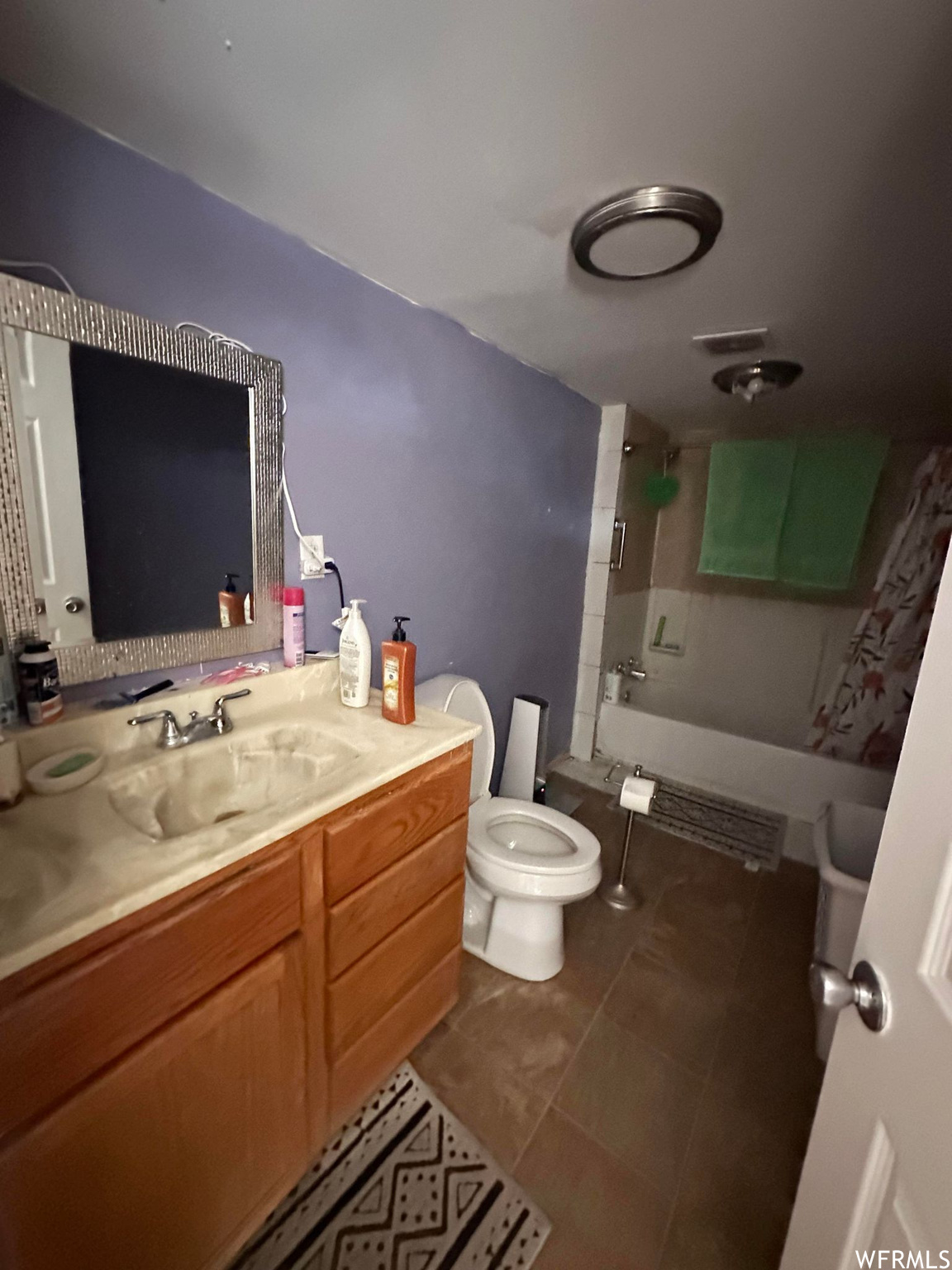 Full bathroom featuring toilet, tile floors, tub / shower combination, and large vanity